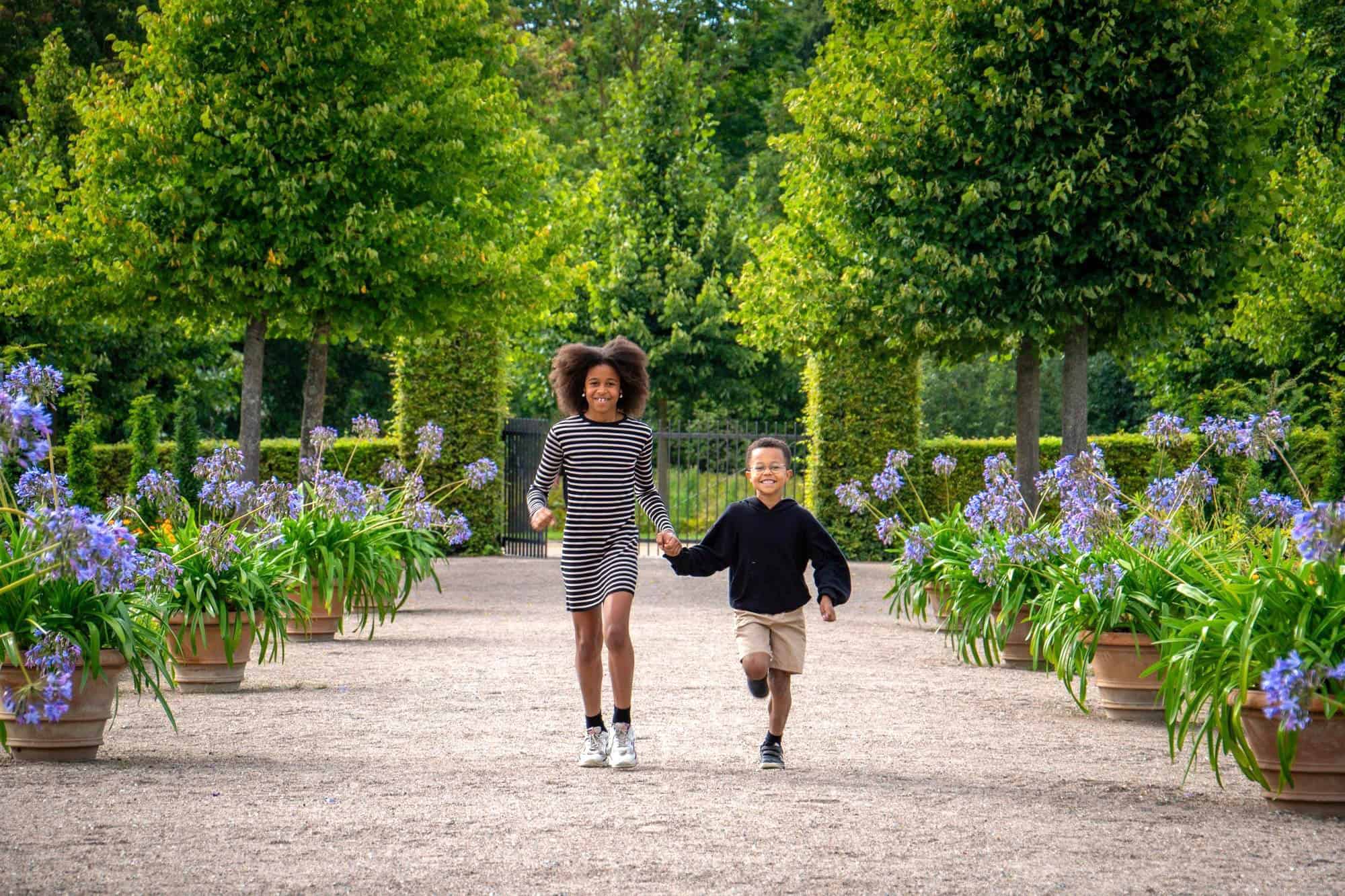 Børnefotografering af søskende der løber i park i Hillerød